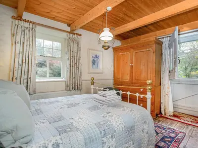 a bedroom with a bed and a wooden ceiling at Hallowarren Barn in Saint Anthony