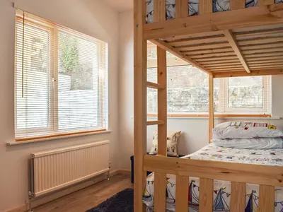 a bedroom with a bunk bed and a window at The Dawn in Looe