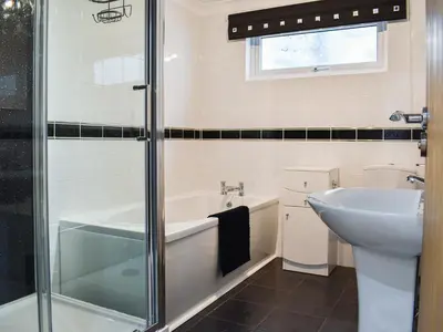 a bathroom with a tub and a sink at The Dawn in Looe