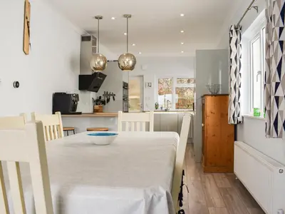 a kitchen and dining room with a table and chairs at The Dawn in Looe