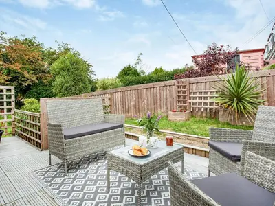 a patio with chairs and a table and a fence at Number One in Saint Dennis