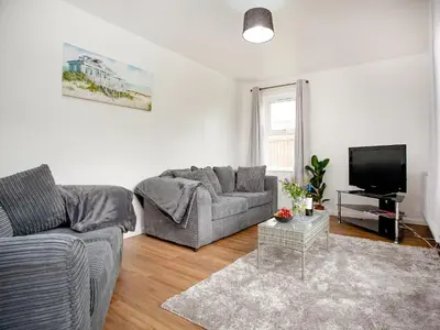 a living room with a couch and a tv at Number One in Saint Dennis