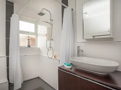 a white bathroom with a sink and a mirror at Number One in Saint Dennis