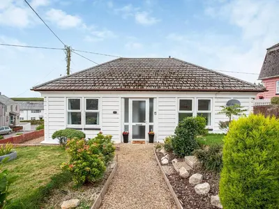 a white house with a brown roof at Number One in Saint Dennis