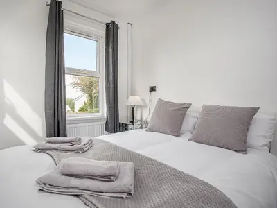a bedroom with a white bed with towels on it at Number One in Saint Dennis