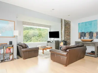 a living room with two leather chairs and a television at 9 Cedars in St. Agnes