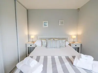 a bedroom with a bed and two night stands at 9 Cedars in St. Agnes