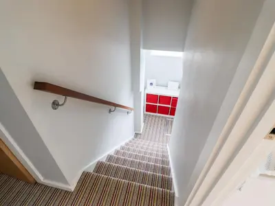 a staircase in a room with a red cabinet at 9 Cedars in St. Agnes