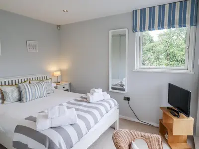 a bedroom with a bed and a tv and a window at 9 Cedars in St. Agnes