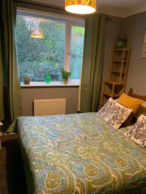 a bedroom with a bed with a large window at Silverspring Farm En suite in Constantine