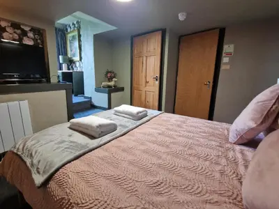 a bedroom with a bed with two towels on it at Goonearl Simply Stay in Scorrier