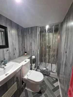 a bathroom with a toilet and a shower and a sink at Goonearl Simply Stay in Scorrier