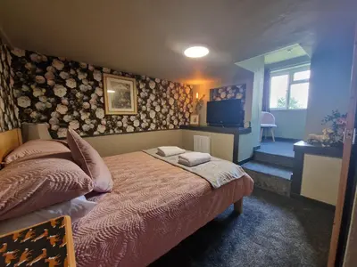 a bedroom with a bed and a television in it at Goonearl Simply Stay in Scorrier