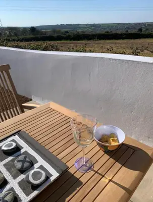 a table with a wine glass and a bowl of nuts at Citrus Chalet in Redruth