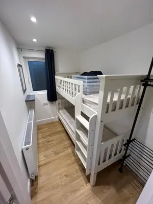 a white bunk bed in a room with a staircase at Citrus Chalet in Redruth