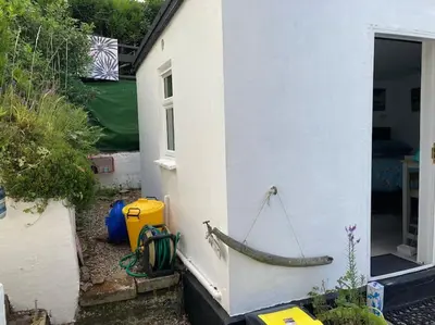 a boat is attached to the side of a house at Guest house Truro garden retreat in Kenwyn