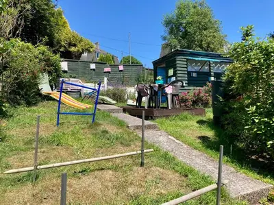 a playground with two slides in a yard at Guest house Truro garden retreat in Kenwyn