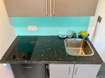 a kitchen with a sink and a counter top at Guest house Truro garden retreat in Kenwyn