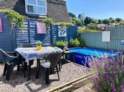 a patio with a table and chairs in a garden at Guest house Truro garden retreat in Kenwyn