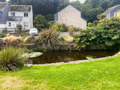 a garden with a pond in a yard at Merizac in Budock Water