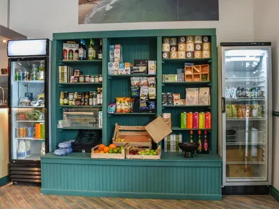 a shop with a green counter with food and drinks at Merizac in Budock Water