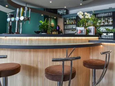 a bar with two stools at a counter in a restaurant at Merizac in Budock Water
