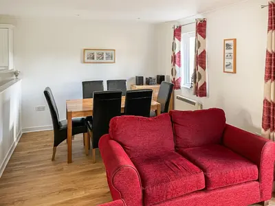 a living room with a red couch and a table at Merizac in Budock Water