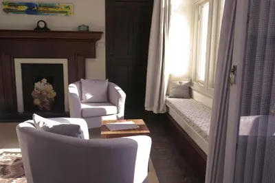 a living room with two chairs and a window at Costislost House in Wadebridge