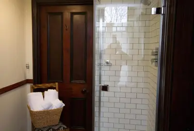 a bathroom with a shower with a basket of towels at Costislost House in Wadebridge