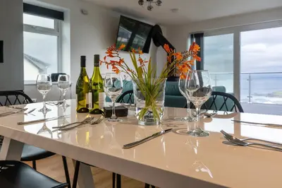 a table with wine glasses and a vase with flowers at Lanyon in St Ives