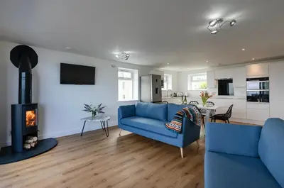 a living room with a blue couch and a fireplace at Treen in St Ives