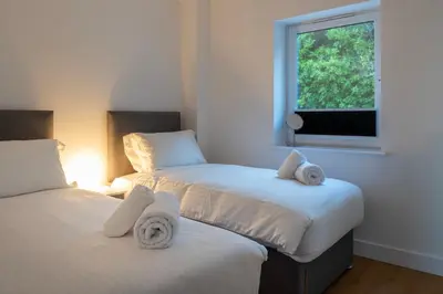 two beds in a room with a window at Treen in St Ives