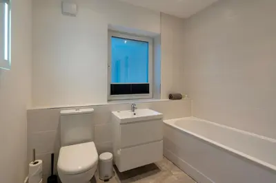 a bathroom with a toilet and a sink and a tub at Treen in St Ives