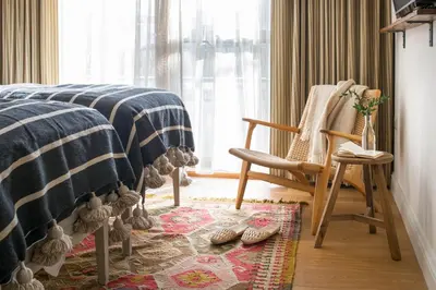 a bedroom with a bed and a chair and a window at Mabyn in Porth