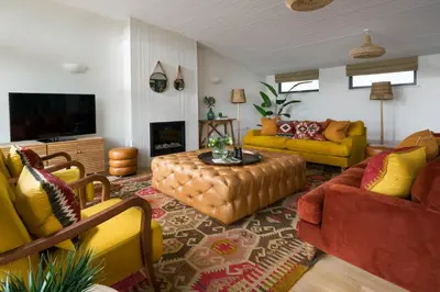 a living room with yellow and orange furniture at Mabyn in Porth