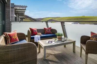 a patio with chairs and a table on a balcony at Mabyn in Porth