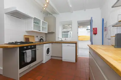 a kitchen with a stove and a dishwasher at Floyd's in St Ives