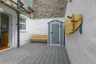 a door on the side of a building with a surfboard at Floyd's in St Ives