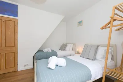 two twin beds in a room with a ladder at Floyd's in St Ives