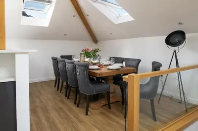 a dining room with a wooden table and black chairs at Cedar Lodge in Carbis Bay