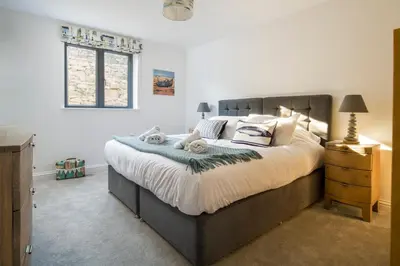 a bedroom with a large bed and a window at Cedar Lodge in Carbis Bay
