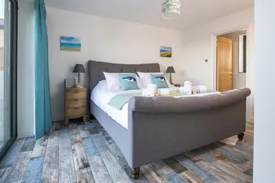 a bedroom with a large bed with blue pillows at Cedar Lodge in Carbis Bay