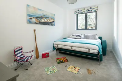 a bedroom with a bed and a desk and a chair at Cedar Lodge in Carbis Bay