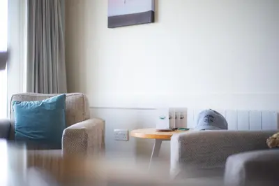 a room with a table and two chairs and a blue pillow at Trevose Golf and Country Club in Padstow