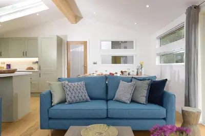 a blue couch in a living room next to a kitchen at 4 Valley View in Looe