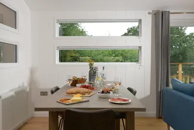 a dining room with a table with food and a window at 4 Valley View in Looe