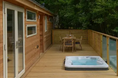 a deck with a hot tub and a table on it at 4 Valley View in Looe