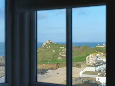 a window with a view of a beach and the ocean at Luxurious apartment, 180° beach views & parking in St Ives