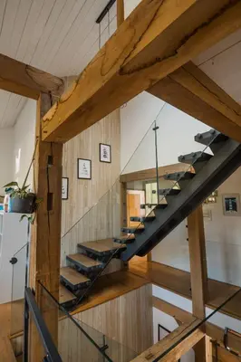 a staircase in a house with wooden beams at The Farmhouse in Porth