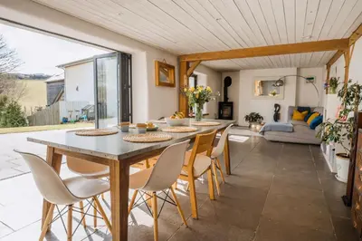 a kitchen and living room with a table and chairs at The Farmhouse in Porth